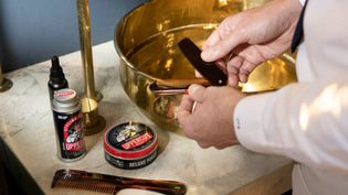  Man holding folding comb with grooming products next to sink | Style Standard