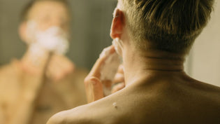 Shirtless blonde man applying shaving cream in mirror | Style Standard